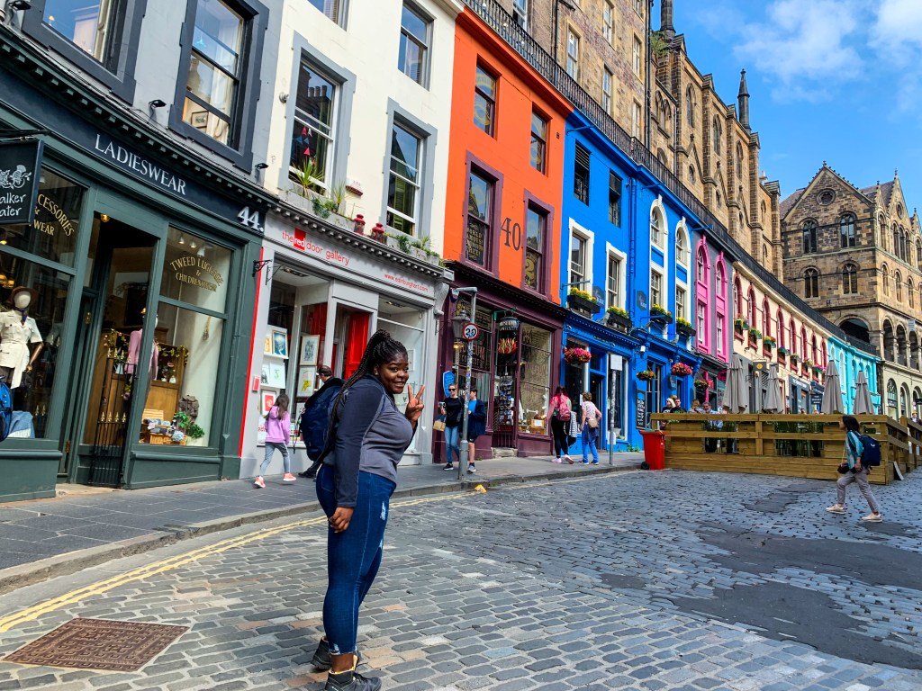 Sarah posing with a peace sign on Victoria Street in Edinburgh Scotland